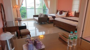 A hotel room with a bed, a sofa, a table with cups and bottles, and a view of the outside. - GoodEatting (Jiaoxi)