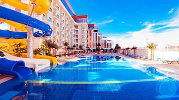 Relax by the pool with lounge chairs and umbrellas, surrounded by a modern building with multiple balconies.