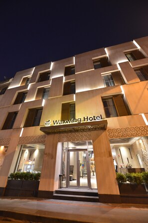 The exterior of the Waxwing Hotel with a modern design, featuring a prominent entrance and a sign above the doors. - Waxwing Hotel (Antakya)