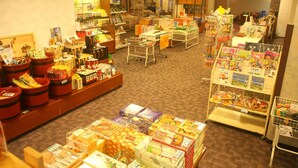 Un supermercado con diversos alimentos y productos exhibidos en estantes y mesas.