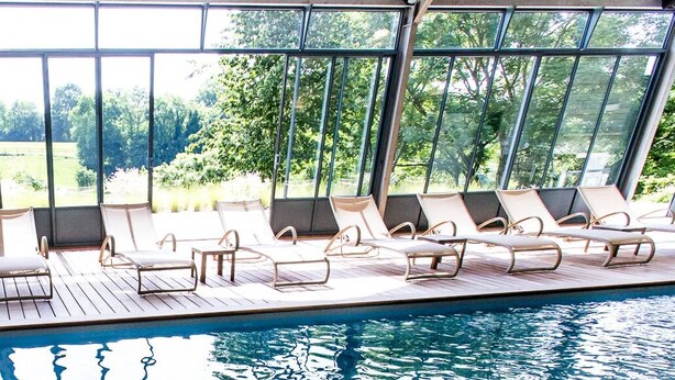 A poolside area with sun loungers and a view of a lush garden through large windows. - Le Clos de Grâce (Honfleur)