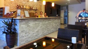 A bar area with a stone wall, hanging lights, and a jukebox. - Purimas Resortel (Rawai)