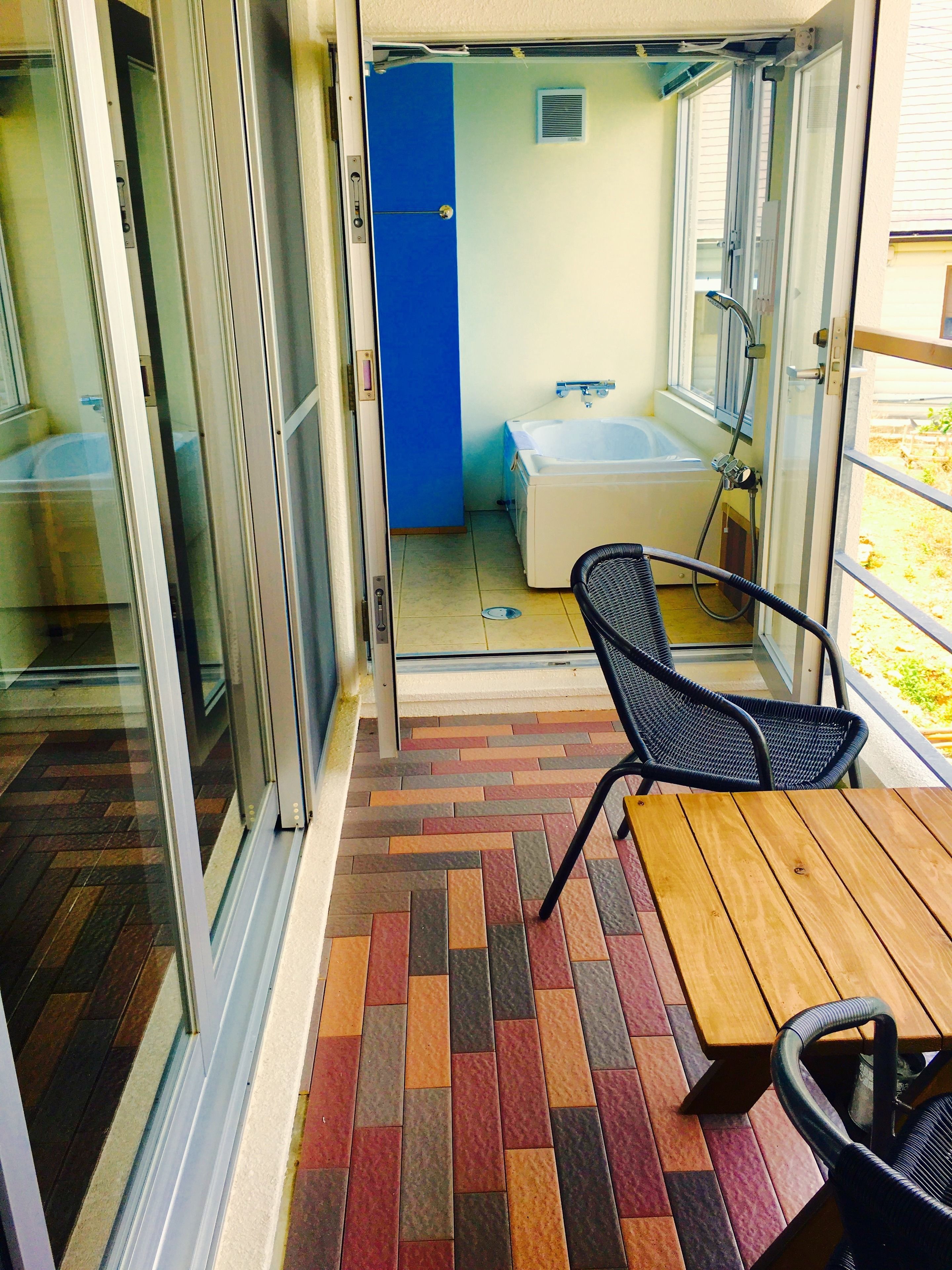 A room with a bathtub, a shower, and a window.
