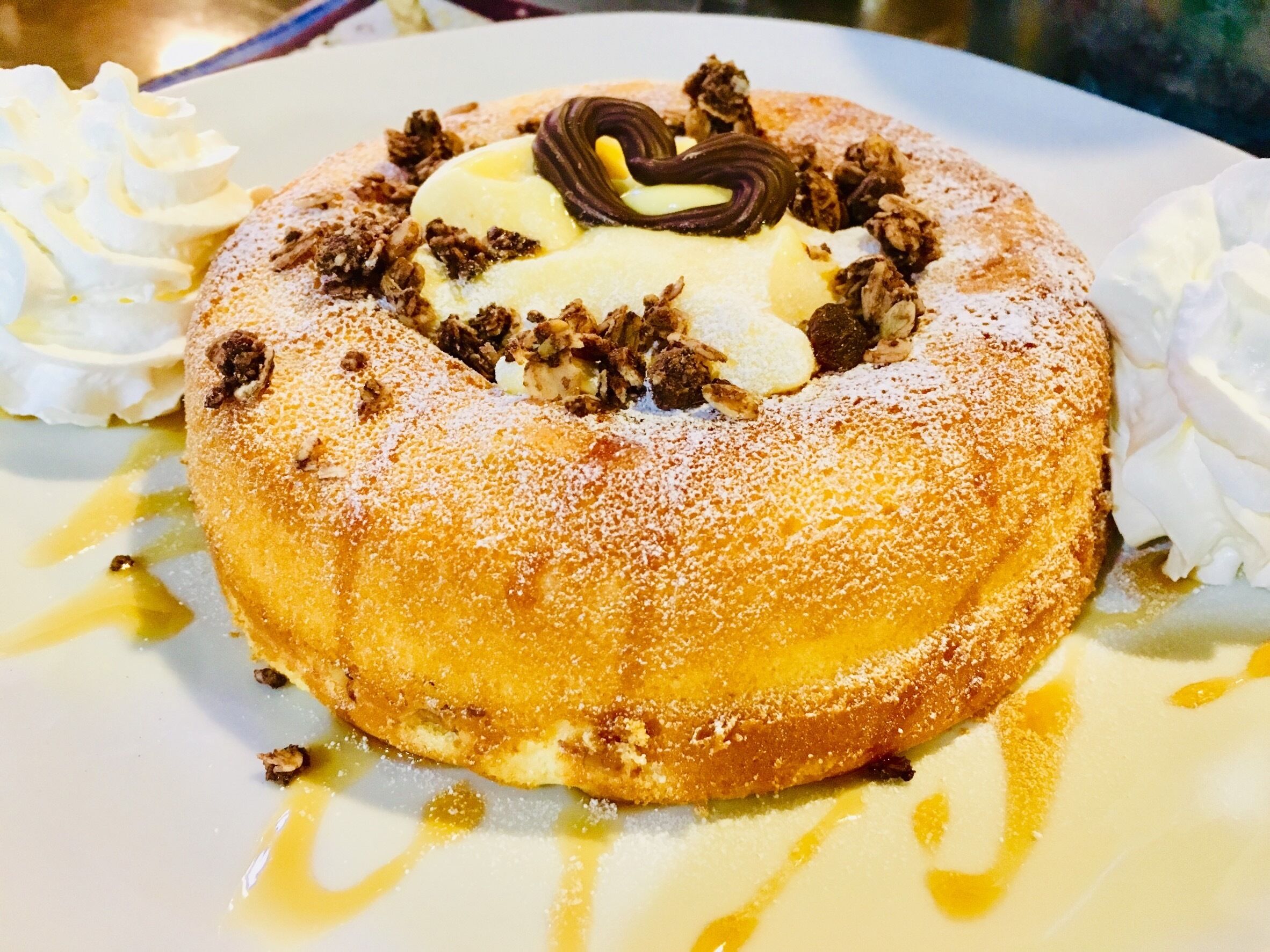 A dessert with whipped cream, chocolate, and nuts on a plate.