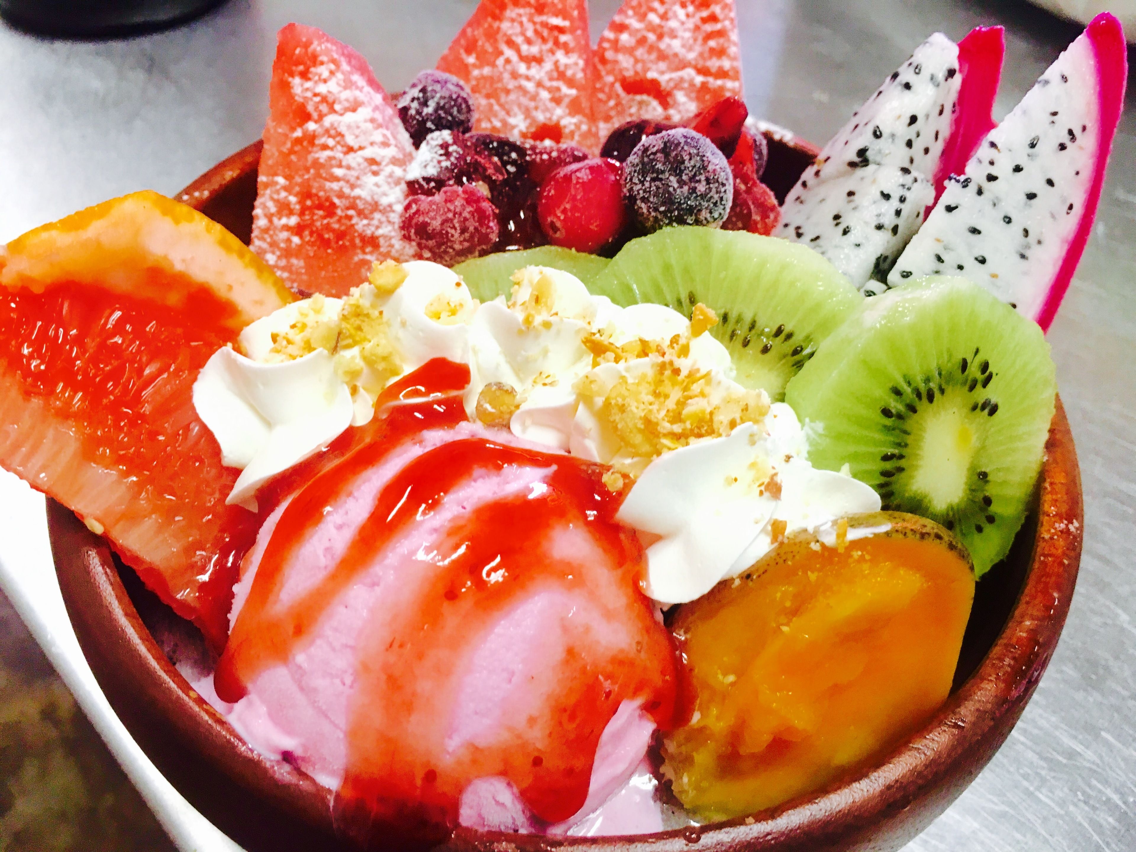A bowl of dessert with various fruits and toppings.
