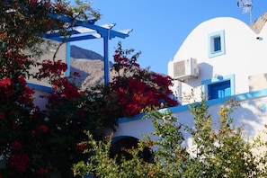 A white building with blue accents and red flowers.