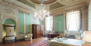 A room with a chandelier, a bed, a desk, and a chair. - Florentapartments - Ponte Vecchio (Florence)