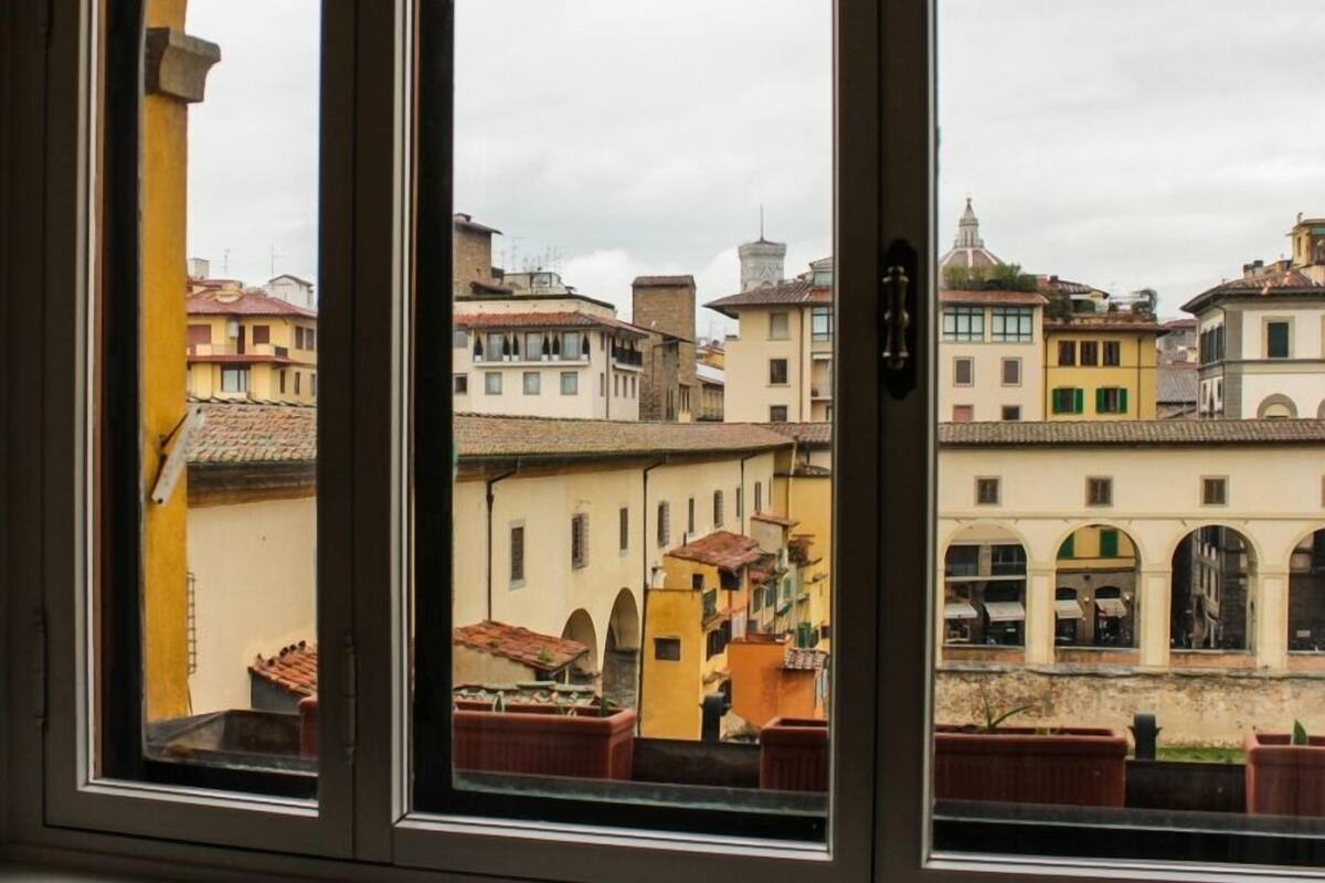 A view through a window of a building with multiple floors, featuring a variety of architectural styles and colors.