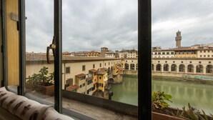 A view of a historic building with a tower and a bridge over a river. - Florentapartments - Ponte Vecchio (Florence)