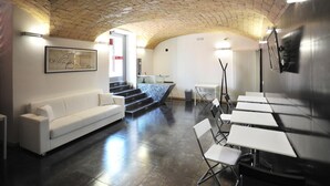 A modern interior with a brick ceiling, white sofas, and foldable tables. - Residenza Adriana (Rome)