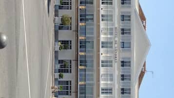 Un hotel con fachada moderna, varios pisos y una entrada destacada.