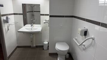 A modern bathroom with a white sink, a toilet, and a shower.