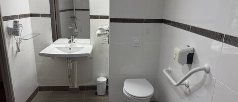 Un baño moderno con un lavamanos blanco, un inodoro y una ducha.