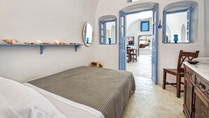 Un dormitorio con una cama, un aparador, un espejo y una estantería decorada.