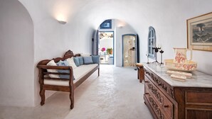 Una habitación con un banco de madera, una encimera de mármol y un acceso a otra habitación.