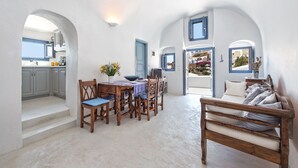 Una habitación amplia con zona de comedor, sofá y vistas al exterior.