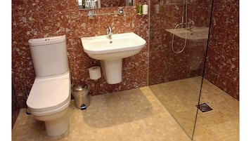 A bathroom with a toilet, sink, and shower.