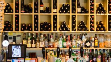 A bar with shelves of various liquor bottles and a computer monitor.