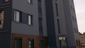 Monikerroksinen asuinkerrostalo, jossa on moderni arkkitehtoninen ilme, parvekkeet ja suuret ikkunat.