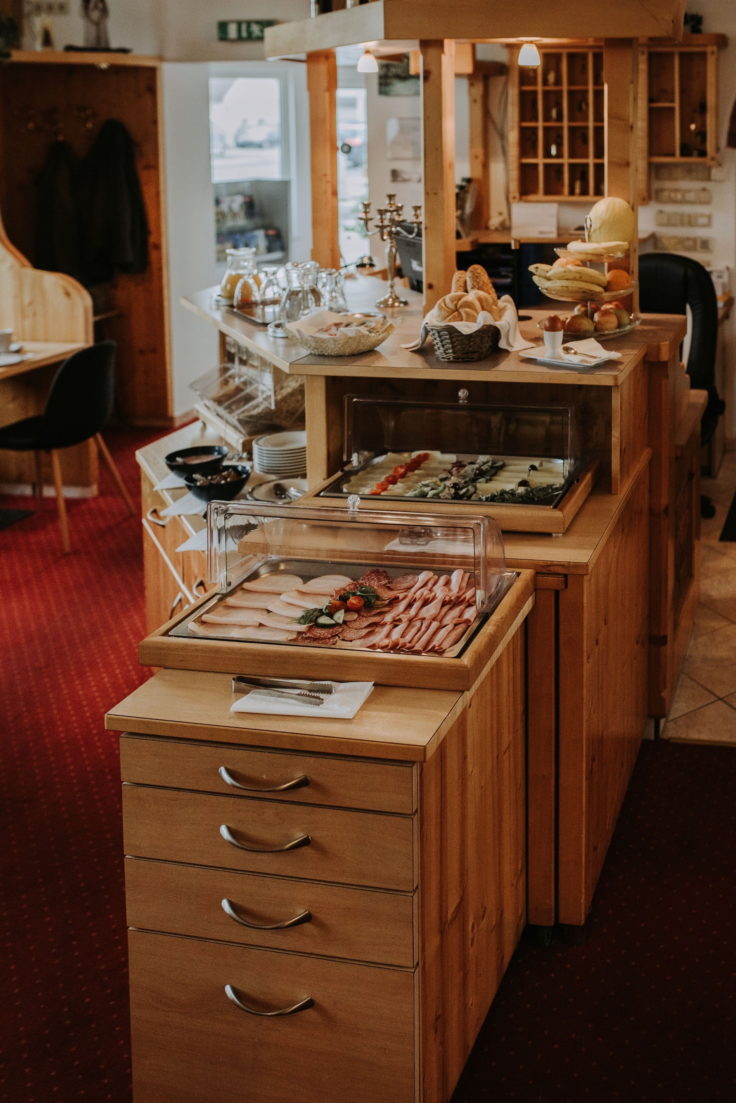 Una mesa de desayuno buffet con diferentes alimentos y una barra de madera.