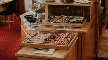 Una mesa de desayuno buffet con diferentes alimentos y una barra de madera.