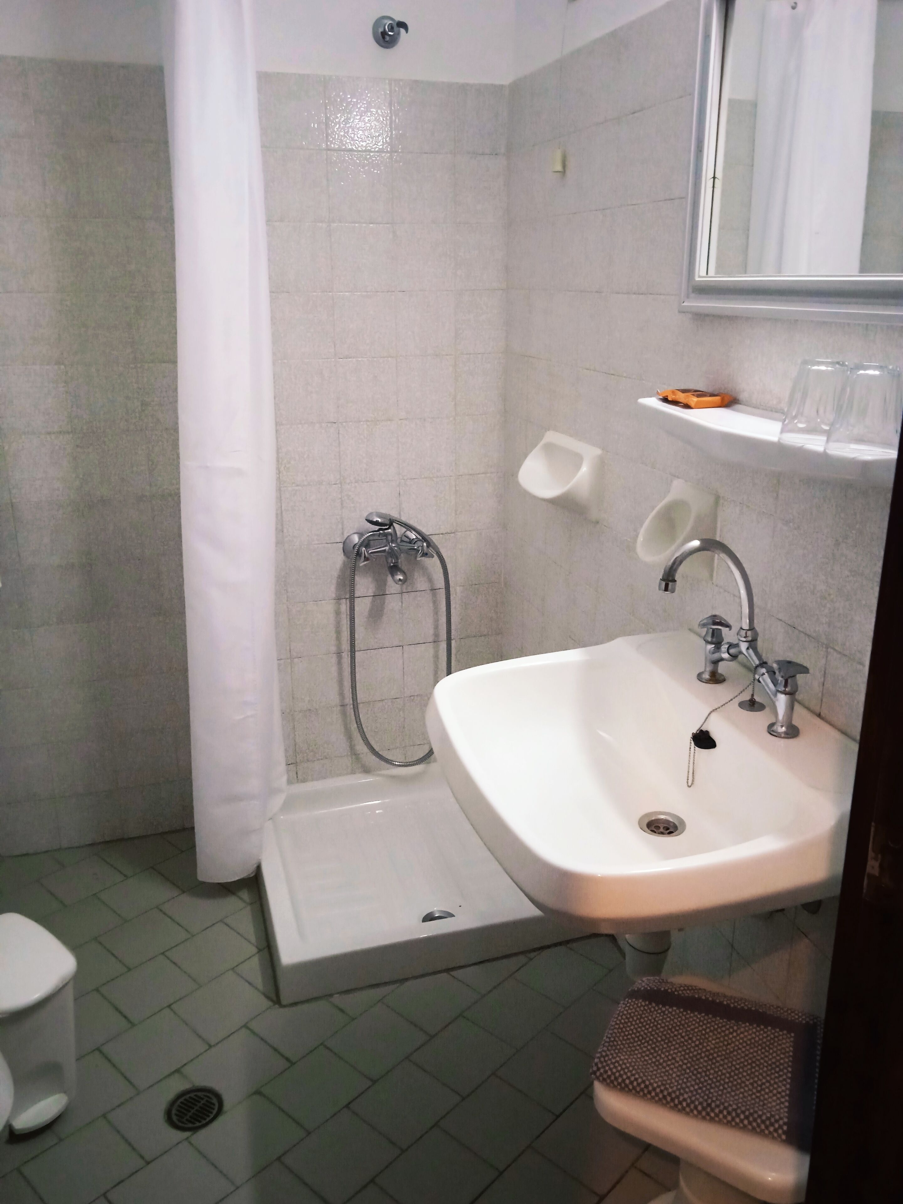 A bathroom with a shower, toilet, and sink.