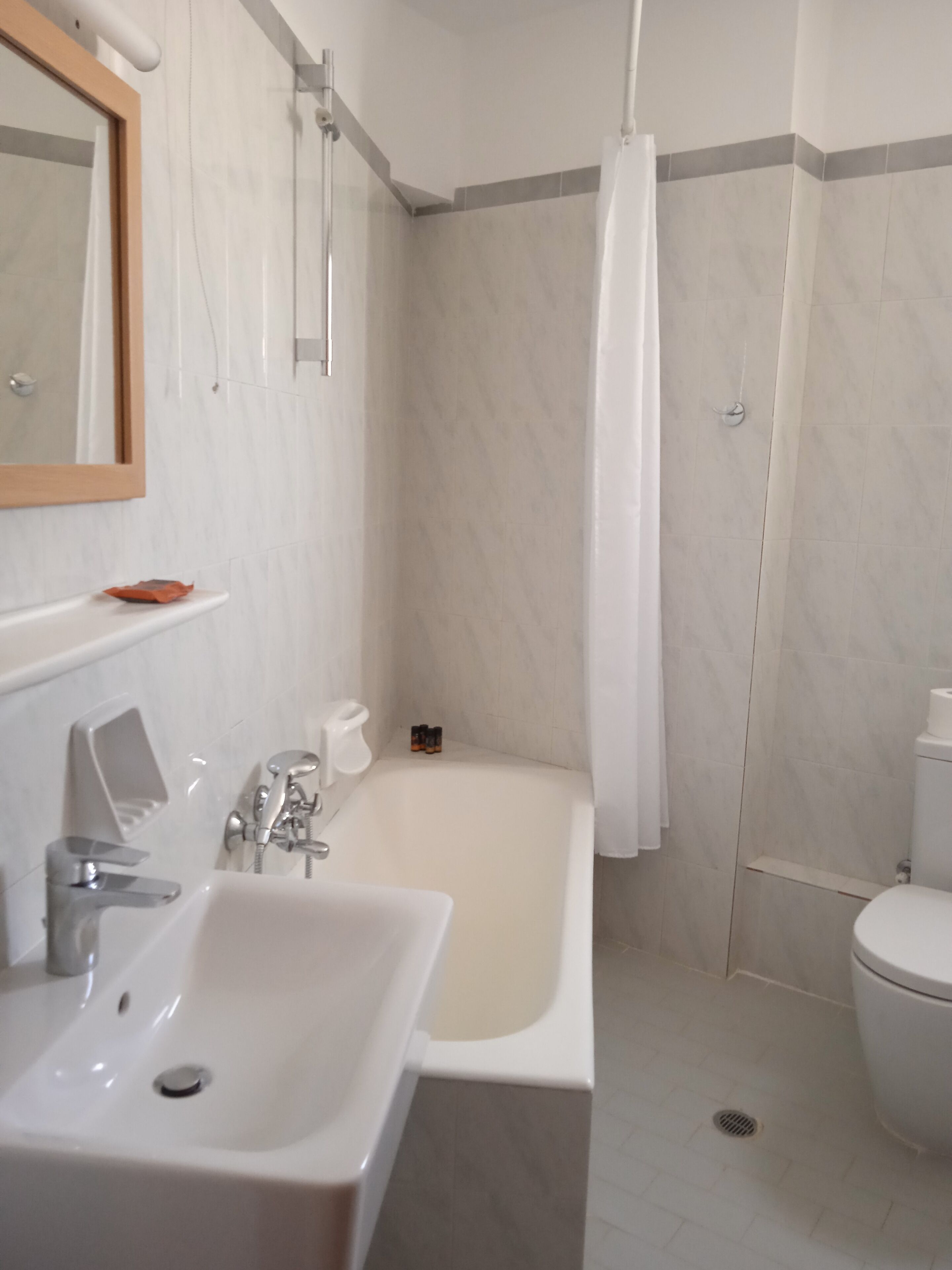 Een badkamer met een bad, een wastafel, een toilet en een douchegordijn.