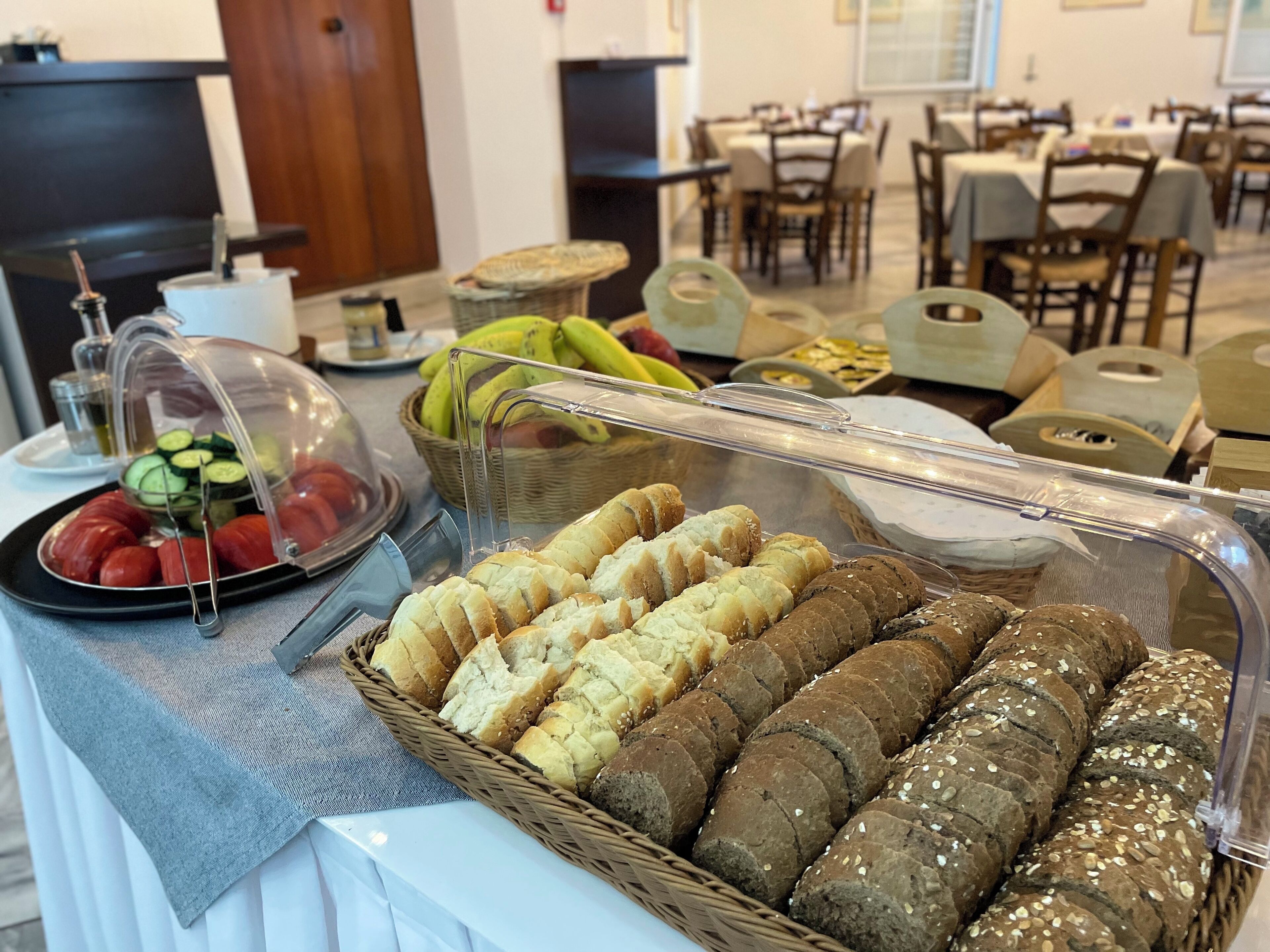 A buffet table with various food items including bread, fruits, and vegetables.