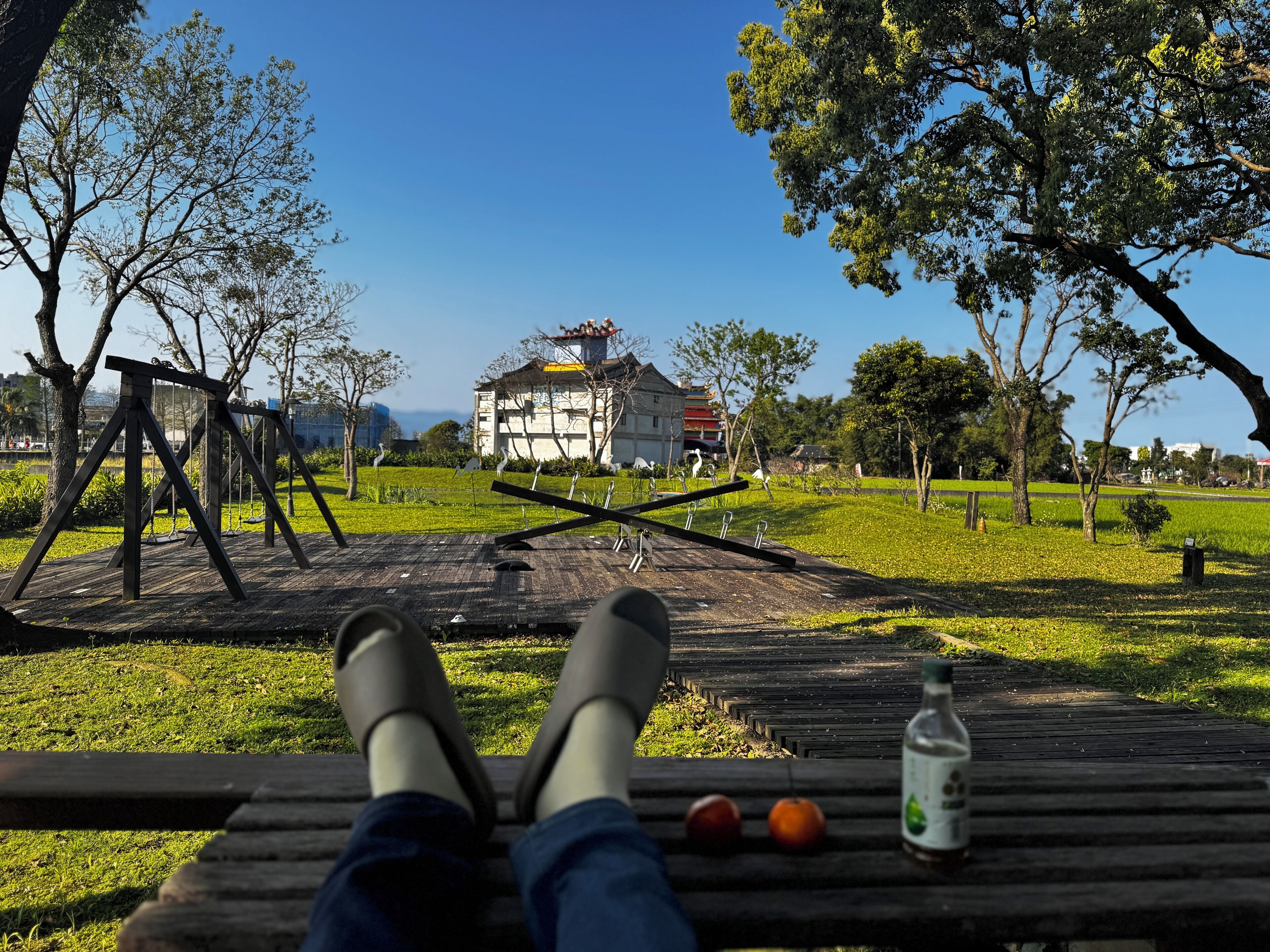 Un parque con un columpio, un banco y una botella de agua.