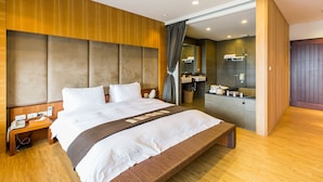 A modern hotel room with a large bed, wooden headboard, and a bathroom visible through an open door. - Serene Gray (Wujie)