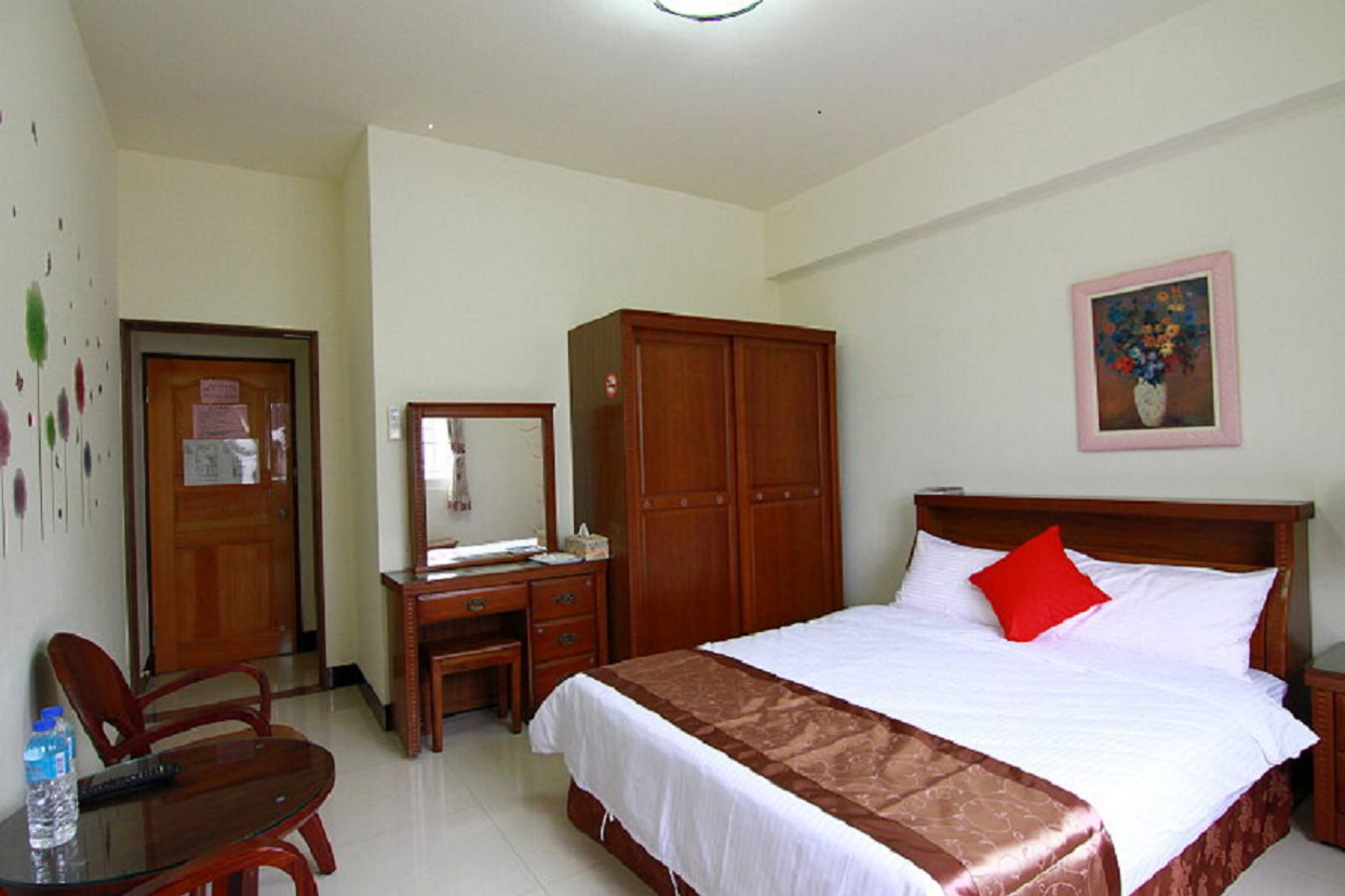 A bedroom with a bed, a desk, a chair, and a wardrobe.