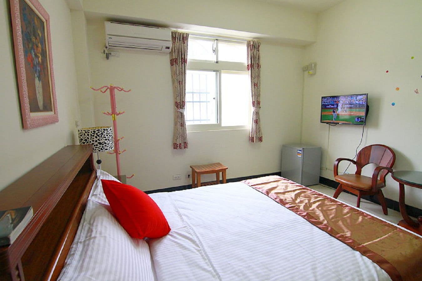 Una habitación de hotel con una cama, televisión, escritorio y una silla.