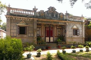 A traditional building with ornate architectural details, a symmetrical facade, and a well-maintained garden with potted plants. - Take a Break Classic B&B (Jincheng)