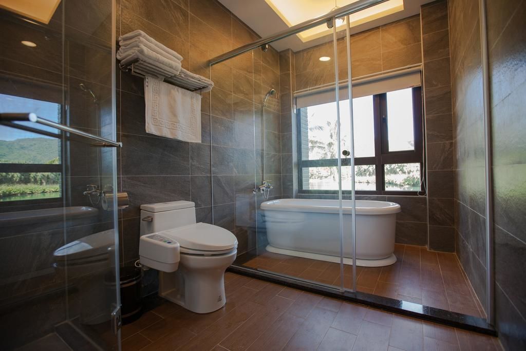 A modern bathroom with a glass-enclosed shower, a toilet, and a bathtub.