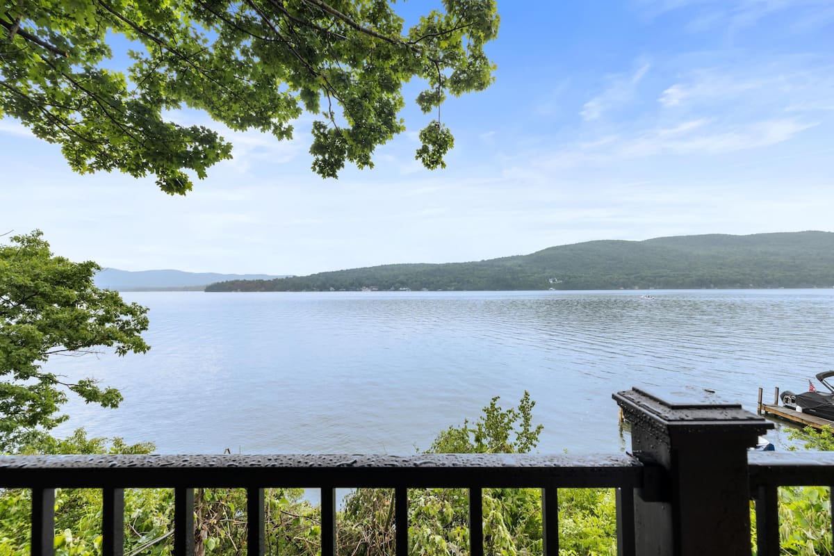 A lake with a view of distant hills and a dock.