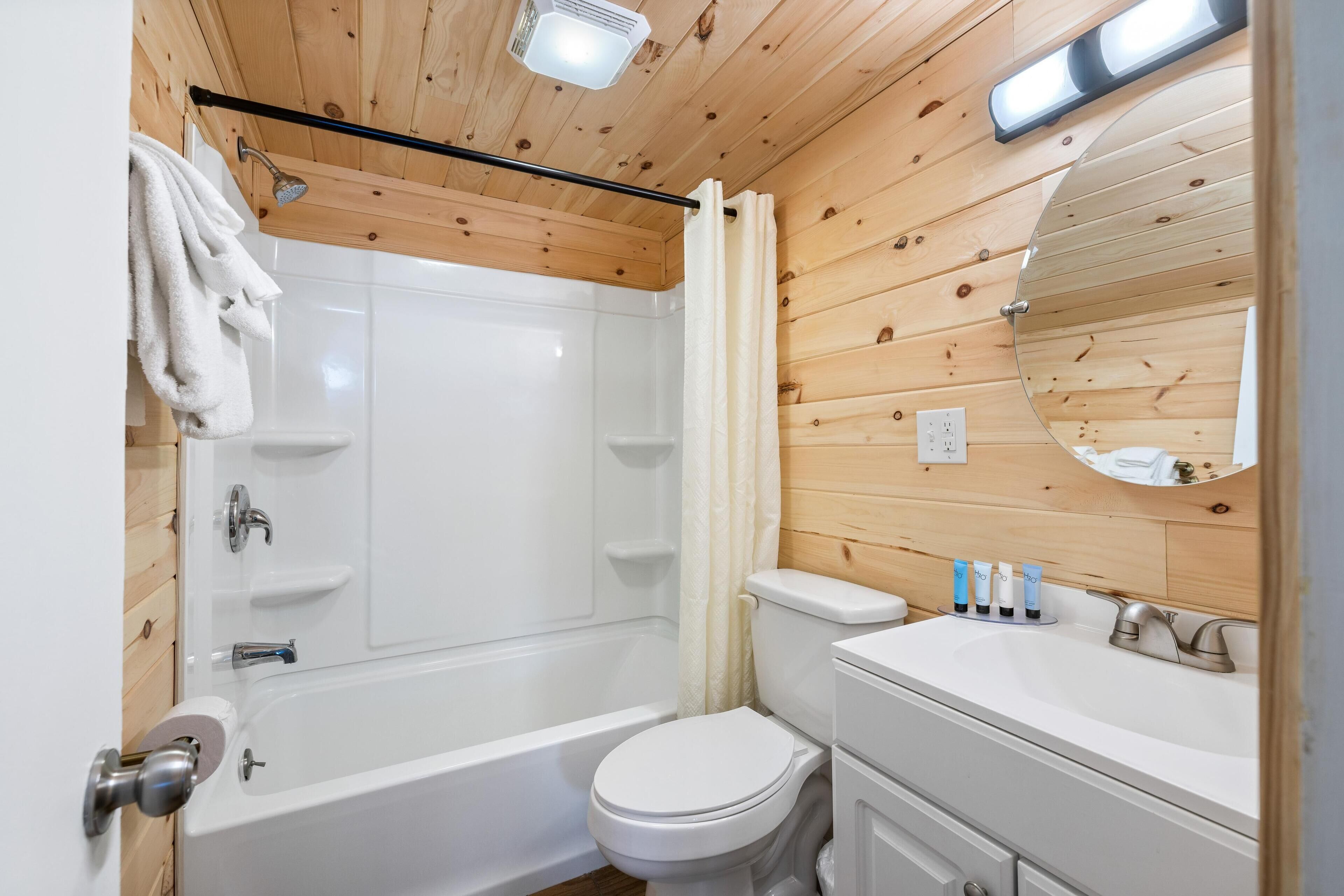A bathroom with a bathtub, toilet, and sink.