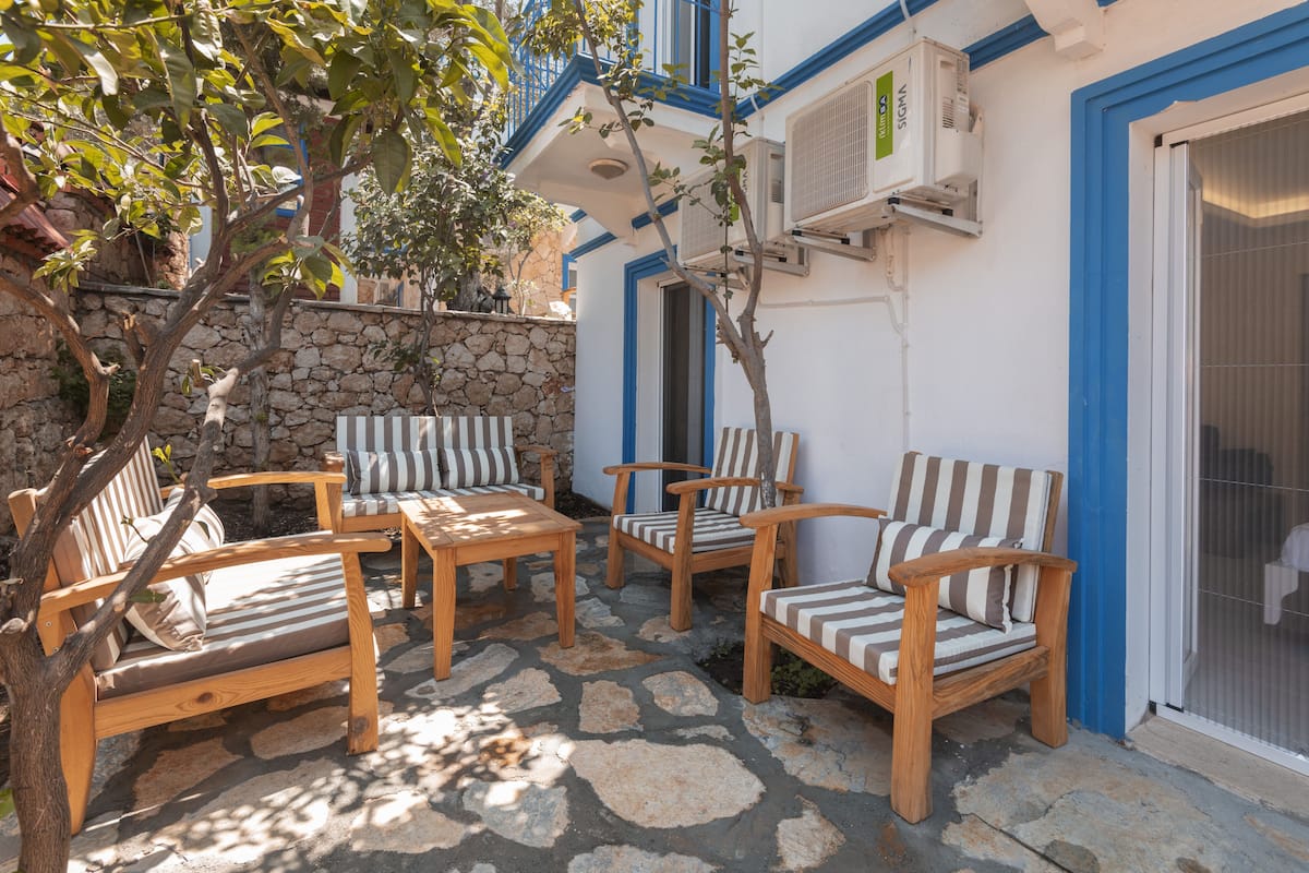 Une terrasse dotée de mobilier en bois et de climatiseurs.