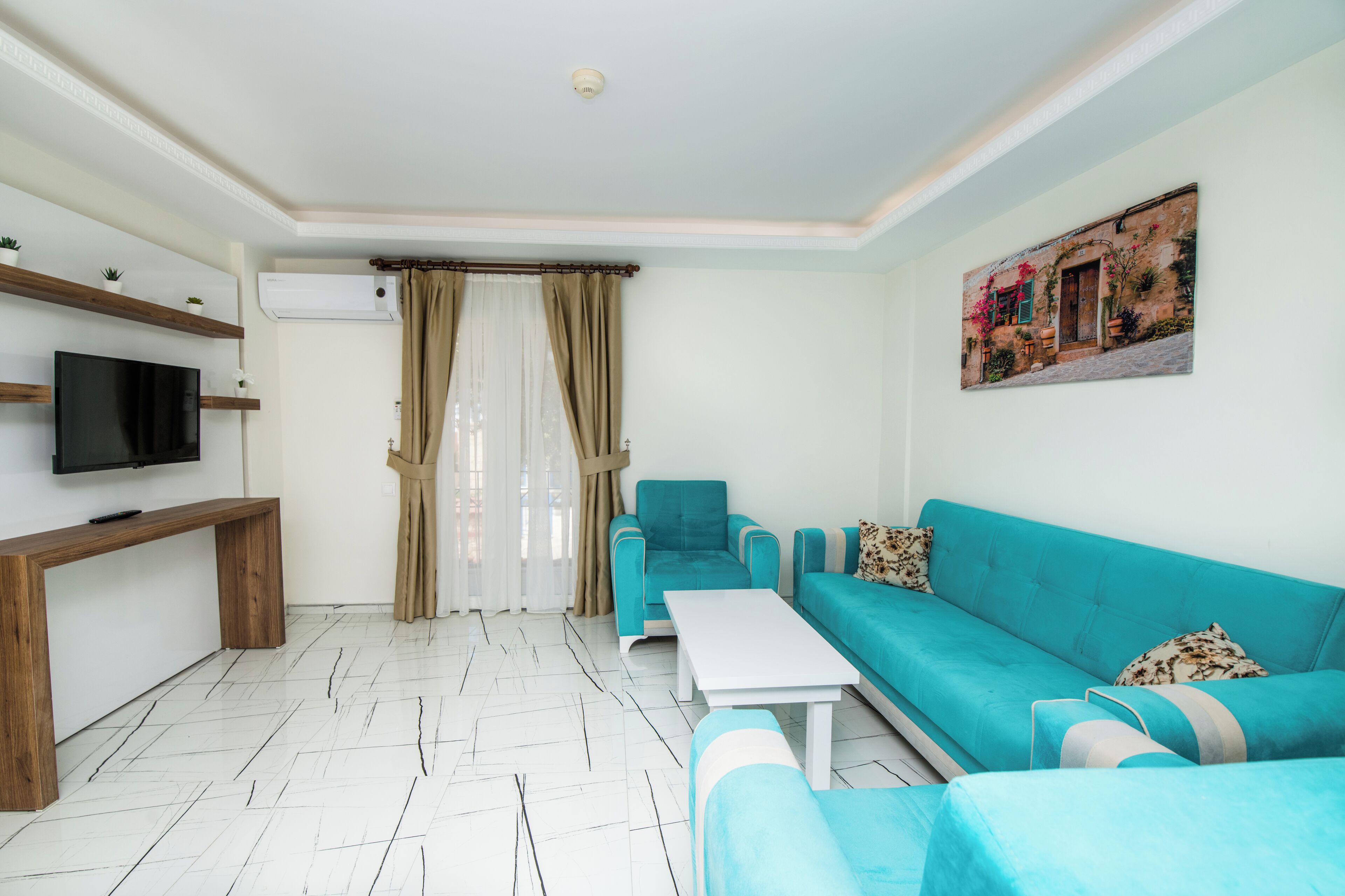 A modern living room with a sofa, a coffee table, a TV, and a painting on the wall.