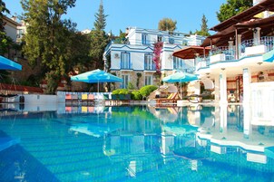 Una piscina al aire libre de temporada, sombrillas