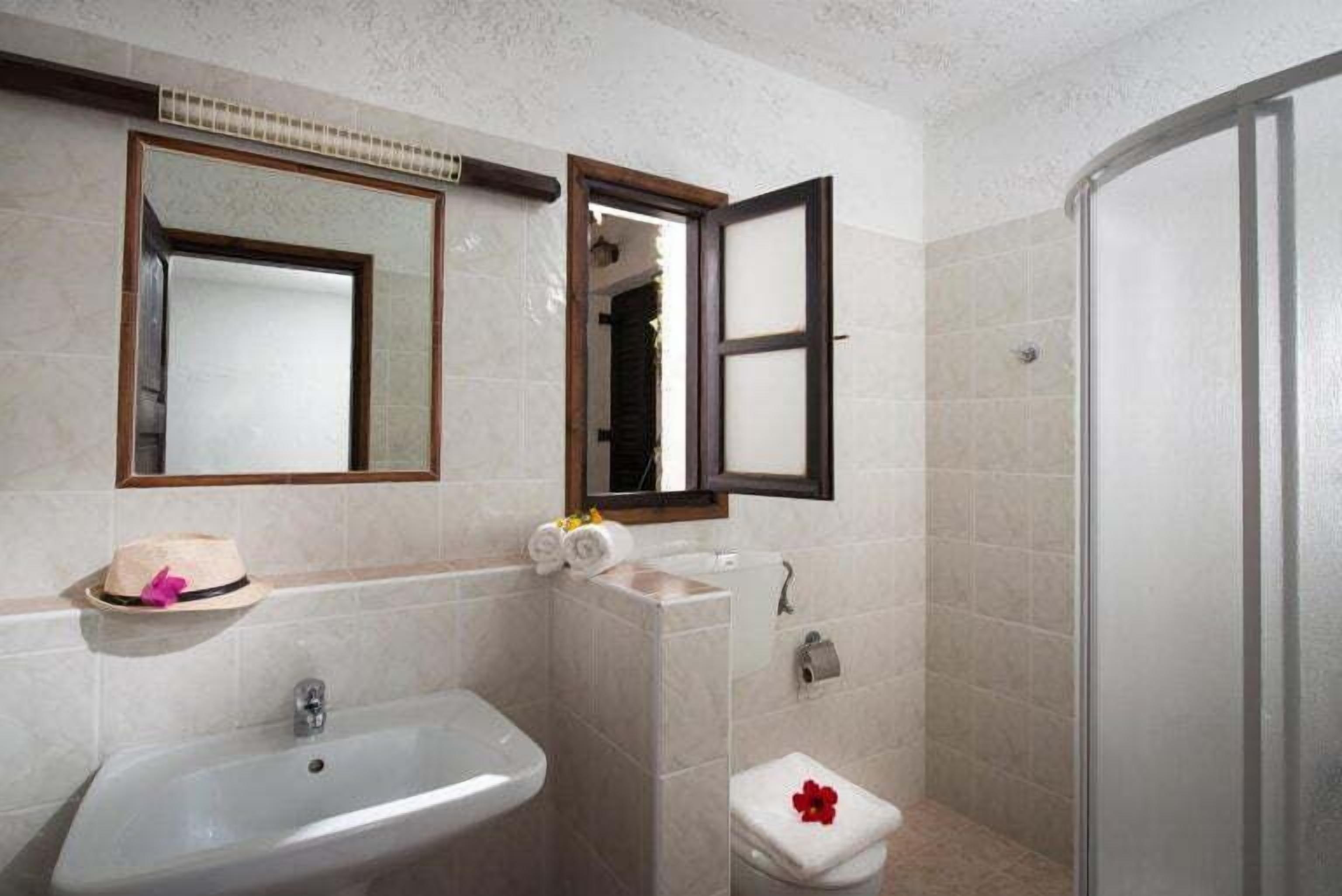 A bathroom with a sink, toilet, and shower.