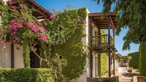 A traditional building with a wooden pergola and a stone staircase leading to a covered area. - Ambelos (Malevizi)