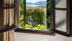 An open window with a view of a mountainous landscape and a body of water. - Ambelos (Malevizi)