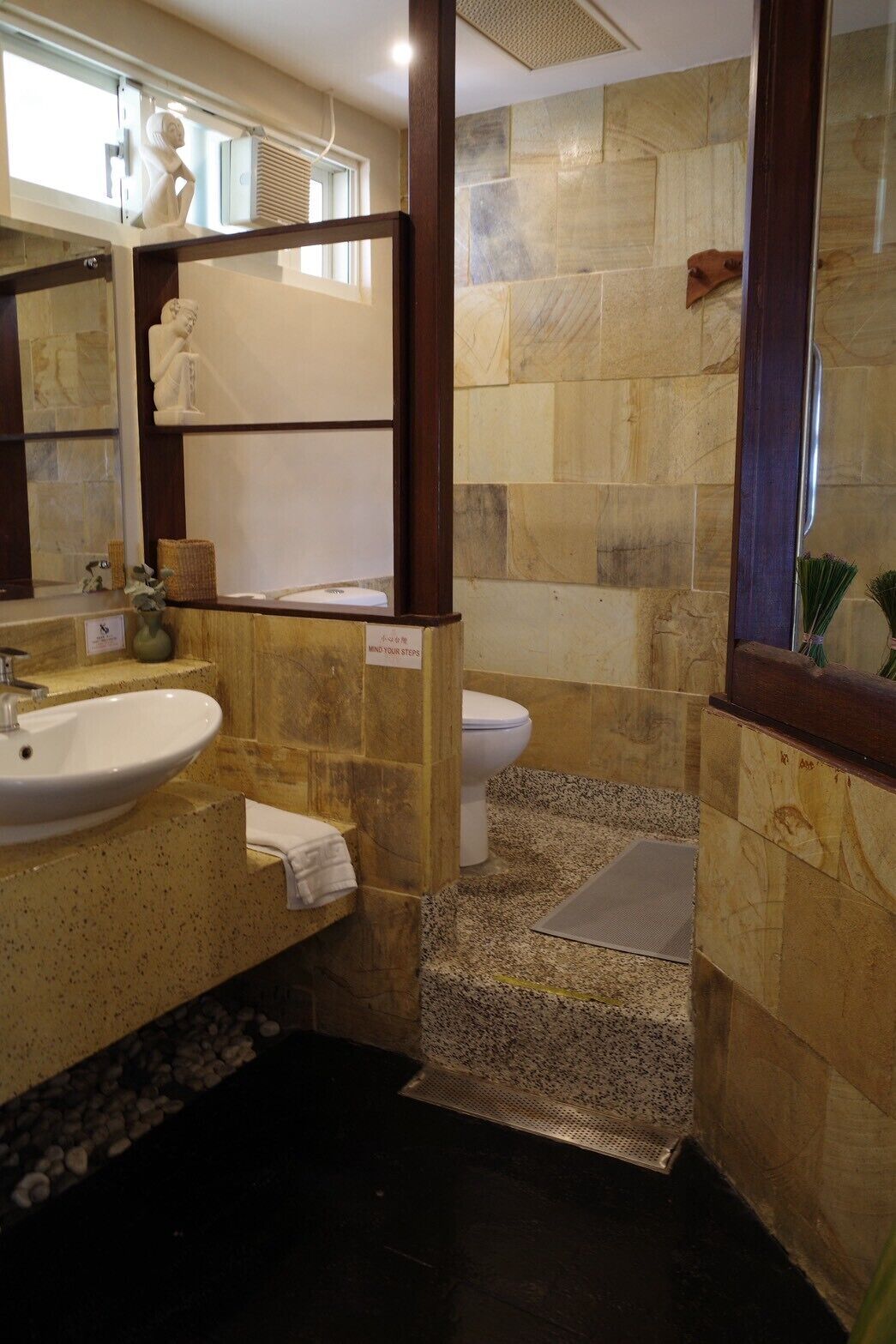 A bathroom with a sink, toilet, and a mirror.
