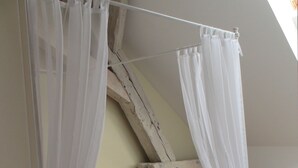 A bedroom with a four-poster bed, white curtains, and a wooden floor. - Landhaus Ribbeck (Nauen)