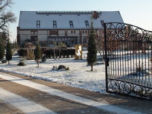 A building with a snow-covered ground, a gated entrance, and a clear sky. - Landhaus Ribbeck (Nauen)