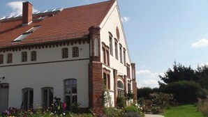 A large, two-story building with a red-tiled roof and a brick facade. - Landhaus Ribbeck (Nauen)