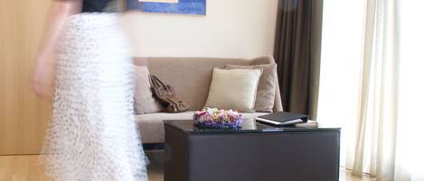 A modern living room with a sofa, coffee table, and artwork on the wall.