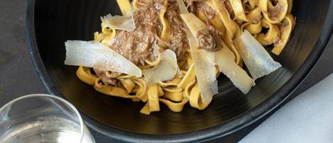 A bowl of pasta with meat and cheese.