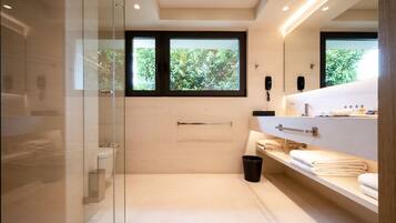 A modern bathroom with a glass shower enclosure, a toilet, a sink with a vanity, and a window providing natural light.