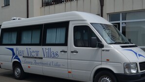 Una camioneta blanca con la marca 'Bay View Villas', que indica que es un vehículo de lujo para las villas.